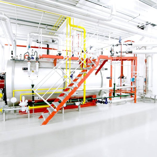 UL-SX packaged steam boiler installed in an industrial boiler room with pipework and access platform